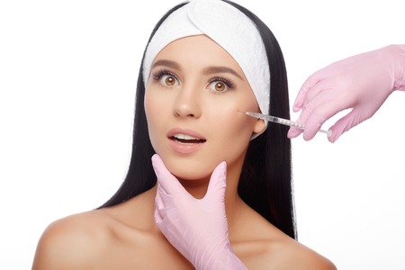 Beautiful woman getting lifting injection in cheekbones. Close-up woman hyaluronic acid injection. Injections of skin rejuvenation. Cosmetic procedures, injections, hyaluronic acid.の写真素材