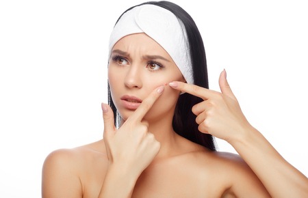 Young woman squeezing her pimple, removing pimple from her face. Woman skin care concept. Acne spot pimple spot skincare beauty care girl pressing on skin problem face.の写真素材