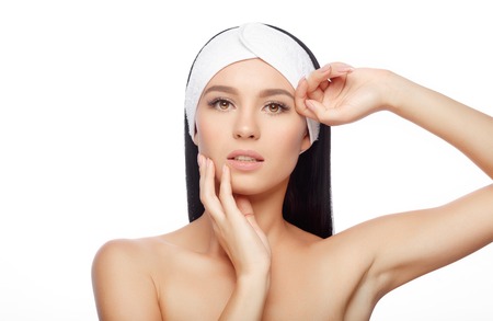 Young Woman in Hairband Touching her Face with a Perfectly Clean Skin. Beautiful Woman Cares for the Skin Face. Skin Care, Cosmetics and Makeup Concept.の写真素材