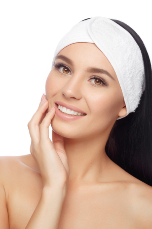 Young Woman in Hairband Touching her Face with a Perfectly Clean Skin. Happy Woman after Bath with Clean Perfect Skin. Skin Care, Cosmetics and Makeup Concept.の写真素材
