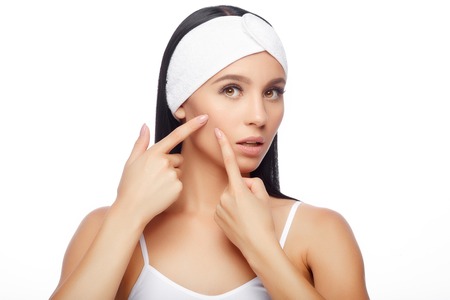 Young woman squeezing her pimple, removing pimple from her face. Woman skin care concept. Acne spot pimple spot skincare beauty care girl pressing on skin problem face.の写真素材