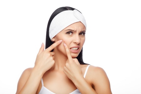Shocked Woman Looking At Pimple On Forehead. Young Woman Squeezing her Pimple, Removing Pimple from her Face. Woman Skin Care Conceptの写真素材