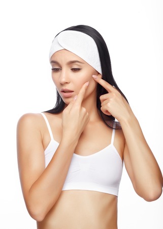 Young woman squeezing her pimple, removing pimple from her face. Woman skin care concept. Acne spot pimple spot skincare beauty care girl pressing on skin problem face.の写真素材