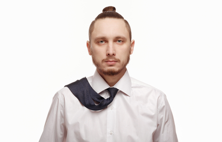 Portrait of young man in white shirt on white background. Man with beard in white shirt and loosened his tieの写真素材