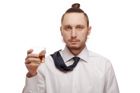 Young man holding glass with alcohol on white background.の写真素材