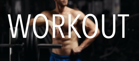 The word WORKOUT in the blurry background bodybuilder in the gym. Workout wordの写真素材