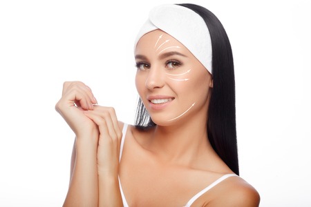 Young Woman in Hairband Touching her Face with a Perfectly Clean Skin. Beautiful Woman Cares for the Skin Face. Skin Care, Cosmetics and Makeup Concept.の写真素材