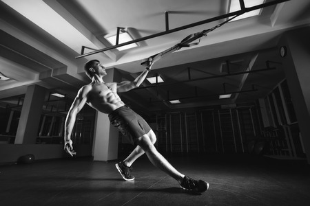 Fitness man workout on the rings. Fitness man in the gym. Fitness style. Workout on rings. Sport and fitnessの写真素材