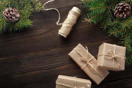 Christmas composition on wooden background with Christmas tree, pine cones and cardboard boxes....