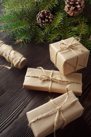 Christmas composition on wooden background with Christmas tree, pine cones and cardboard boxes....