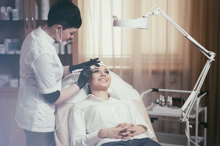 Cosmetologist applying permanent make up on eyebrows- eyebrow tattooの写真素材