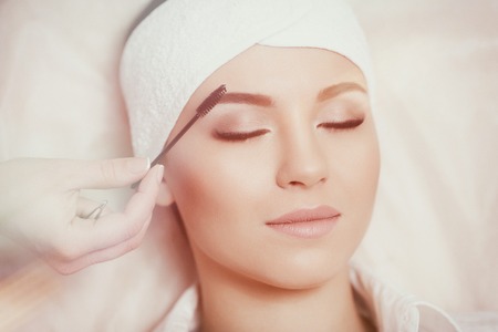 Beautiful young woman gets eyebrow correction procedureの写真素材