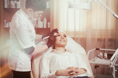 Cosmetologist applying permanent make up on eyebrows- eyebrow tattooの写真素材