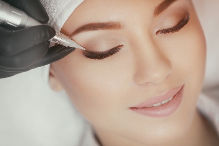 Cosmetologist making permanent make up at beauty salonの写真素材