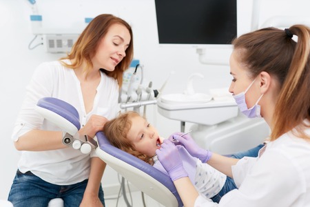 Dentists making treatment for little girlの写真素材