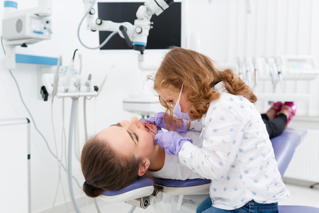 Little girl examining dentist in cabinetの写真素材