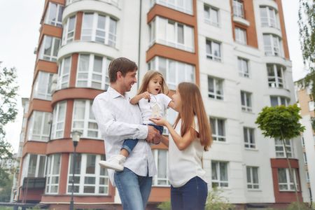 Happy family in front of new apartment buildingの写真素材
