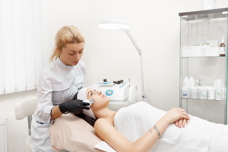 Attractive woman getting facial in modern beauty salon.の写真素材