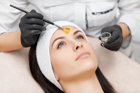 Beautiful woman getting facial peeling mask in beauty salon.の写真素材
