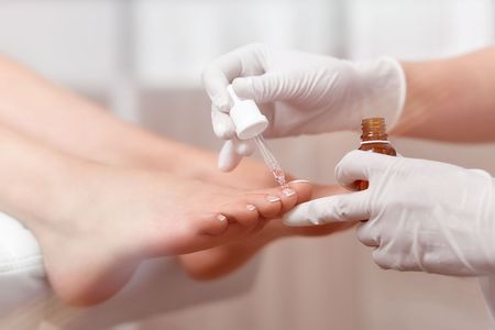 Specialis moisturizing cuticle around nails on feet with oil.の写真素材