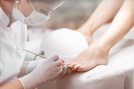 Professional in beauty salon cleaning nails on feet.の写真素材
