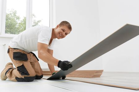 Laying laminate flooring. Floor installation: Close up of New Laminate Floorの写真素材
