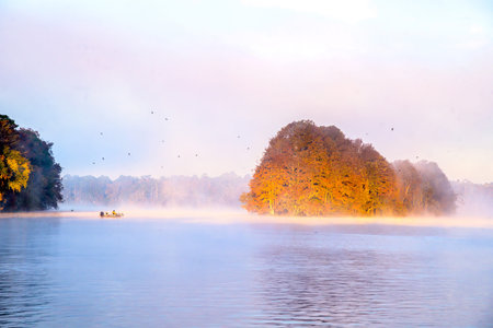 Misty Morning Lake with Autumn Colored Trees and Foliageの写真素材
