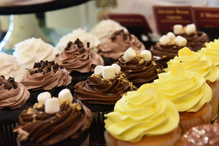 Assorted Cupcakes with frosting and decorations on display at bakery