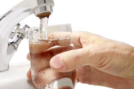 filling a glass with water under the tapの写真素材