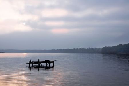 evening sun behind the clouds on the lakeの写真素材