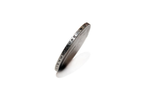 ancient silver coin on edgeの写真素材