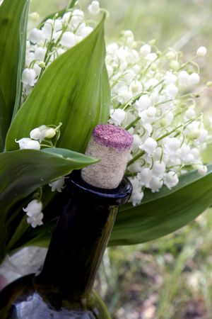 bottle wine with a cork on the background of lily of the valleyの写真素材