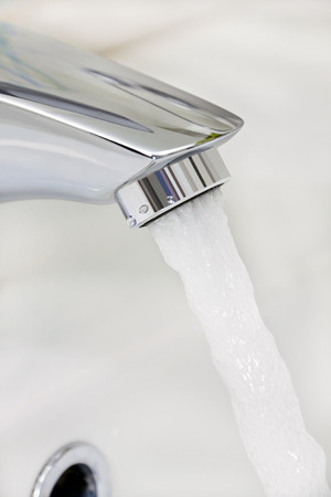 water running from the tap in bathroomの写真素材