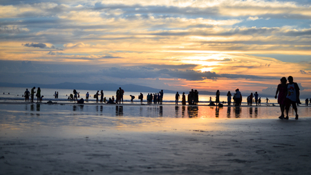 Beautiful Color in Sky during Sunset on a Busy Beachの写真素材