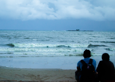 Traveler Couple Sitting together on a Beachの写真素材