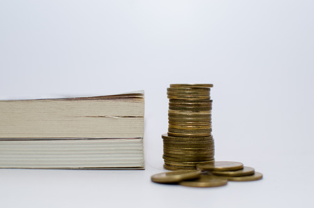 Old books at the background and Money denominations in the foreground symbolizing education and expensive educationの写真素材