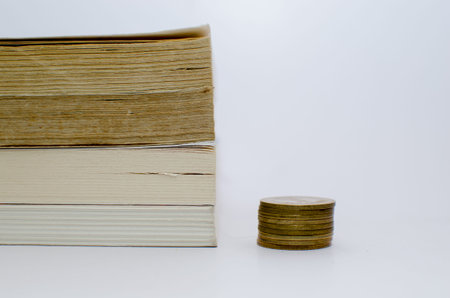 Old books at the background and Money denominations in the foreground symbolizing education and expensive educationの写真素材