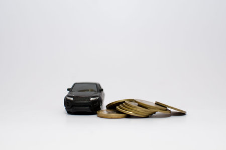 Car mounted on top of pile of coins or denominations symbolizing rise in car pricesの写真素材