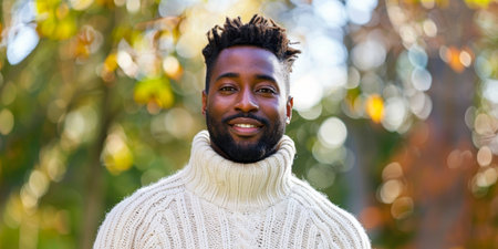 A man with a beard and dreadlocks is wearing a white sweater and smiling. The has a warm and friendly mood, with the man looking happy and relaxedの素材
