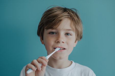 Young Boy Brushing Teeth for Dental Hygiene Against Blue Background.の素材