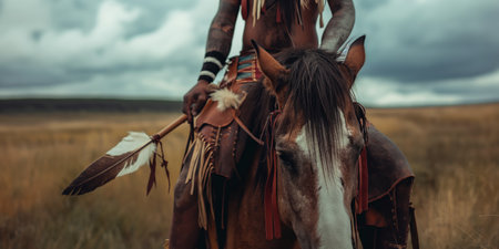 Equestrian Warrior in Traditional Attire Holding Feather on Horseback in Natural Landscape.の素材