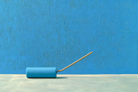 Vibrant Blue Wall with Paint Roller on Concrete Floor.の素材
