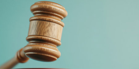 Wooden Gavel Against Blue Background Representing Justice and Legal Authority.の素材
