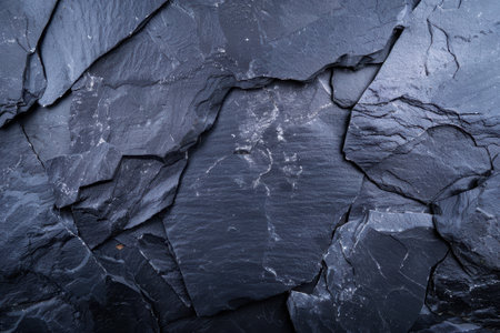 Close up of layered dark slate rocks with natural texture.の素材