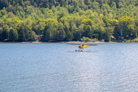 Yellow sea plane landing in Gore Bay on Manitoulin Island on a summer dayのeditorial素材