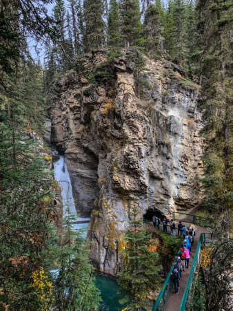 Johnston Canyon, Alberta, Canada - September 28, 2021: Tourists lined up on the trail to go in the cave at the waterfalls at Johnston Canyon in September.のeditorial素材