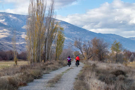 Osoyoos, BC, Canada - November 10, 2021: Two people on e-bikes enjoying a cold November ride on the International Hike and Bike Trail in the Okanagan Valleyのeditorial素材