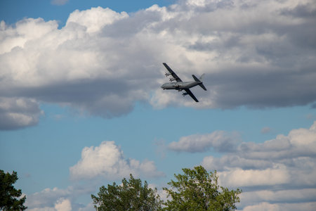 TRENTON, ON, CANADA - JULY 6, 2022: A military plane flys through the sky on a cloudy afternoon