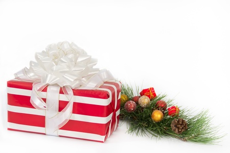 A holiday gift wrapped in bold red and white stripes is topped by a large white bow.の写真素材