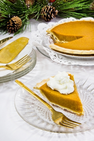 The first slice of pumpkin pie is topped with whipped cream の写真素材